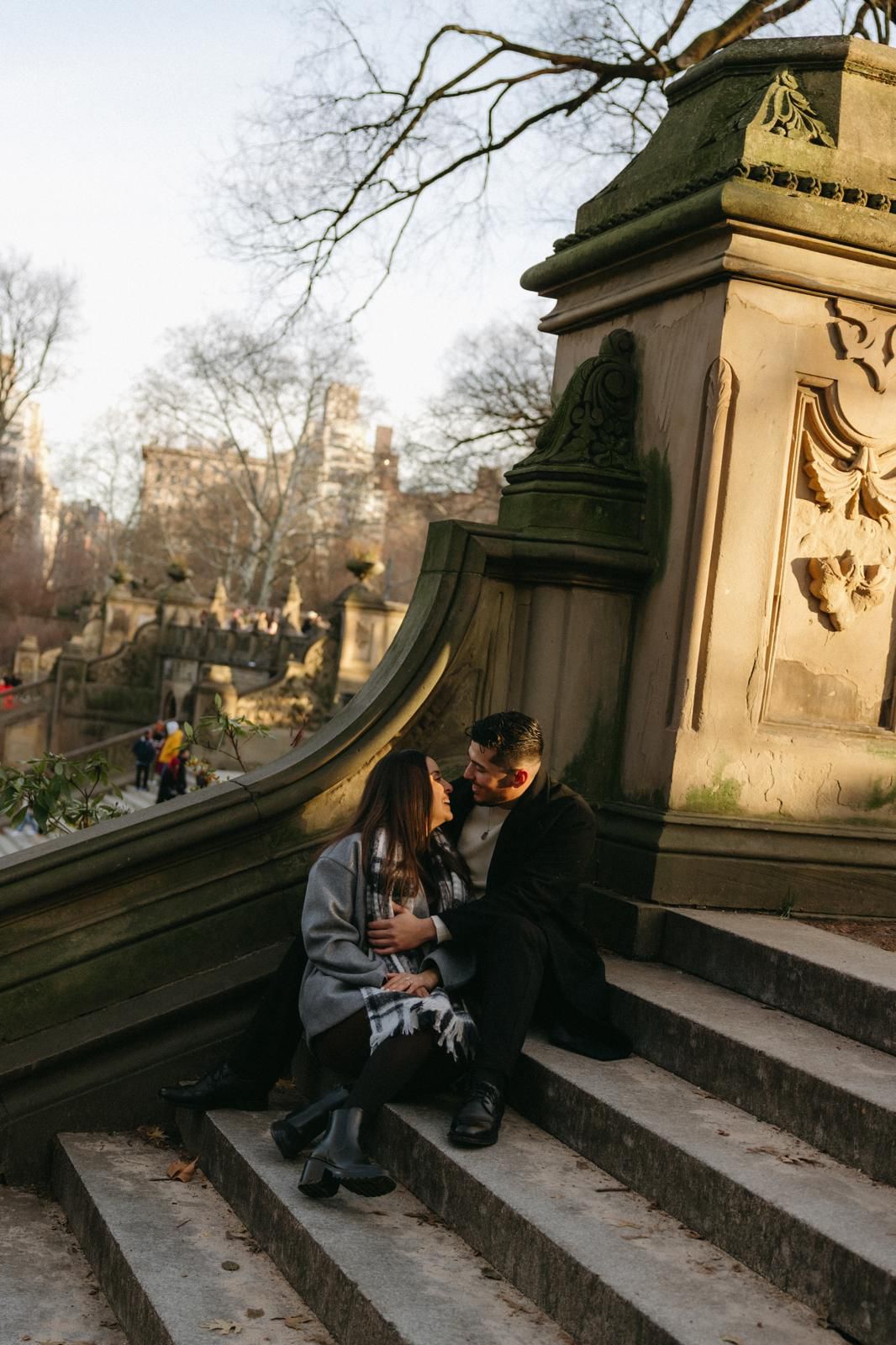 Couple sitting together on ornate stone steps in a park