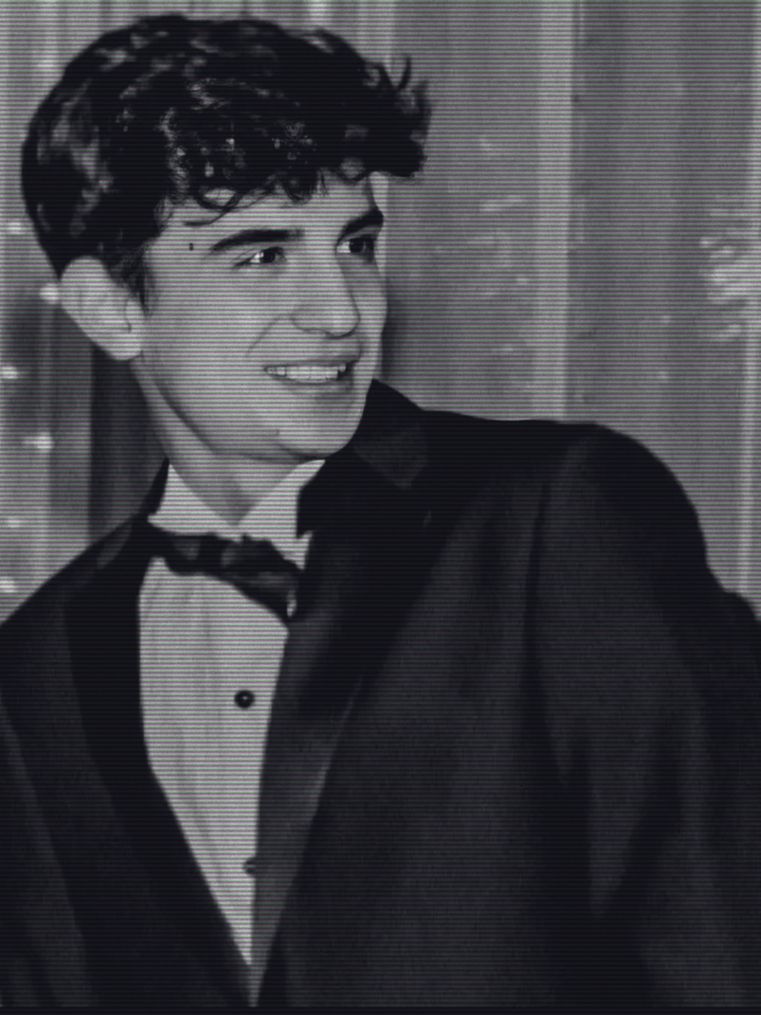 Portrait of the photographer smiling, wearing a suit and bow tie
